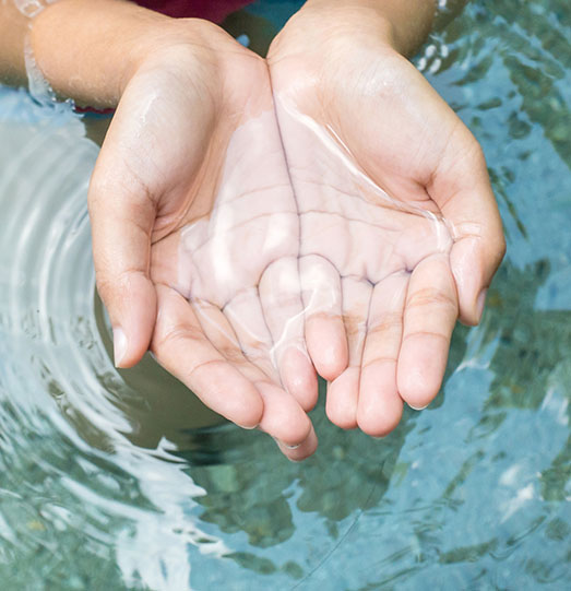 Clear natural water in woman hands.
